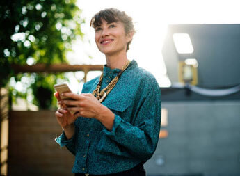 Stock image of a happy woman using a product in the real world.